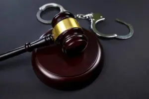 Judge's gavel and handcuffs on a black background