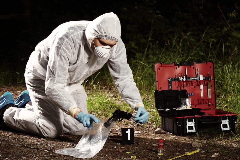 Crime scene investigation - collecting pistol and cartridges by technician